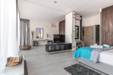 inside-room-bed-tv-grey-wood-floor