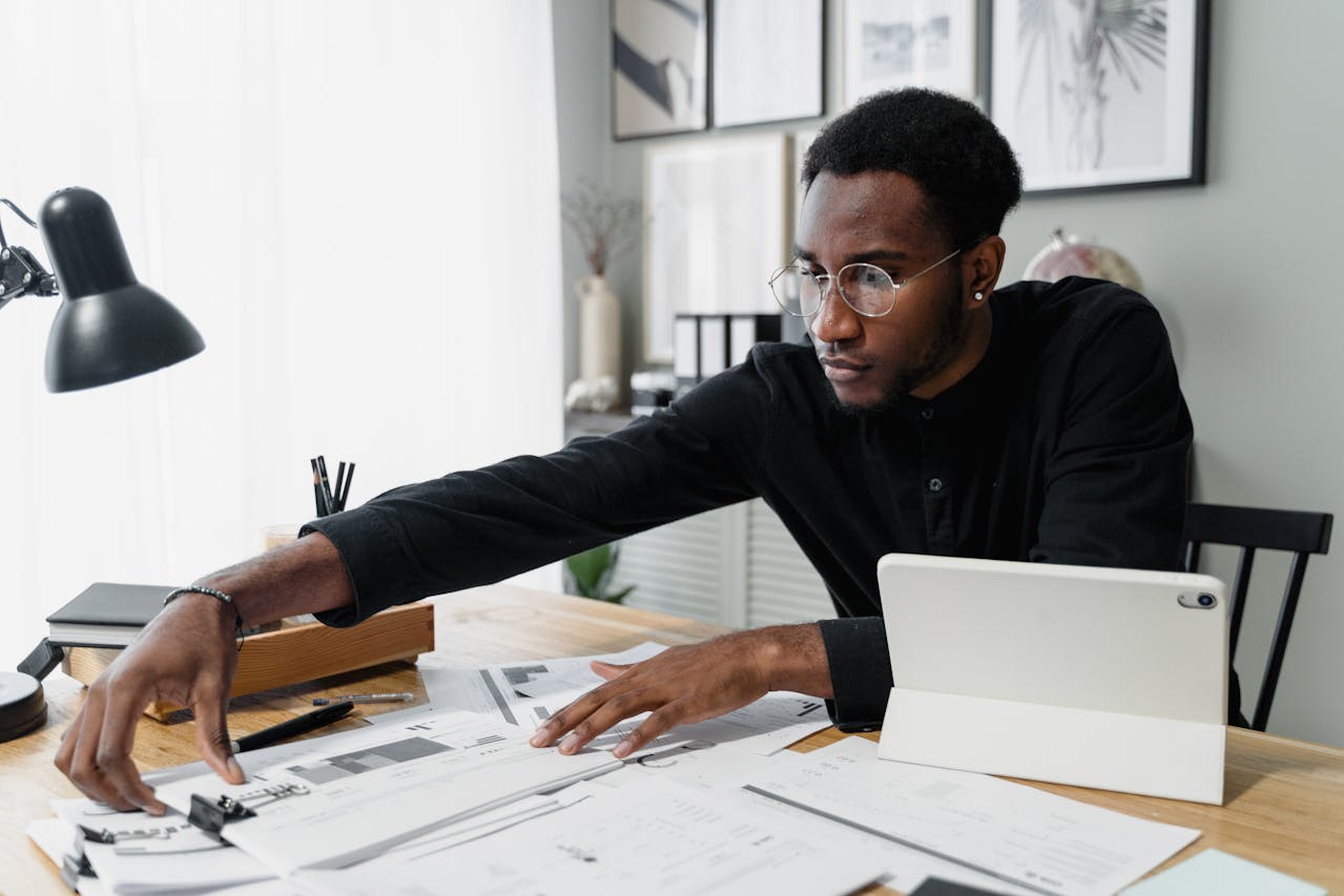 person-looking-at-papers-on-desk person-looking-at-papers-on-desk